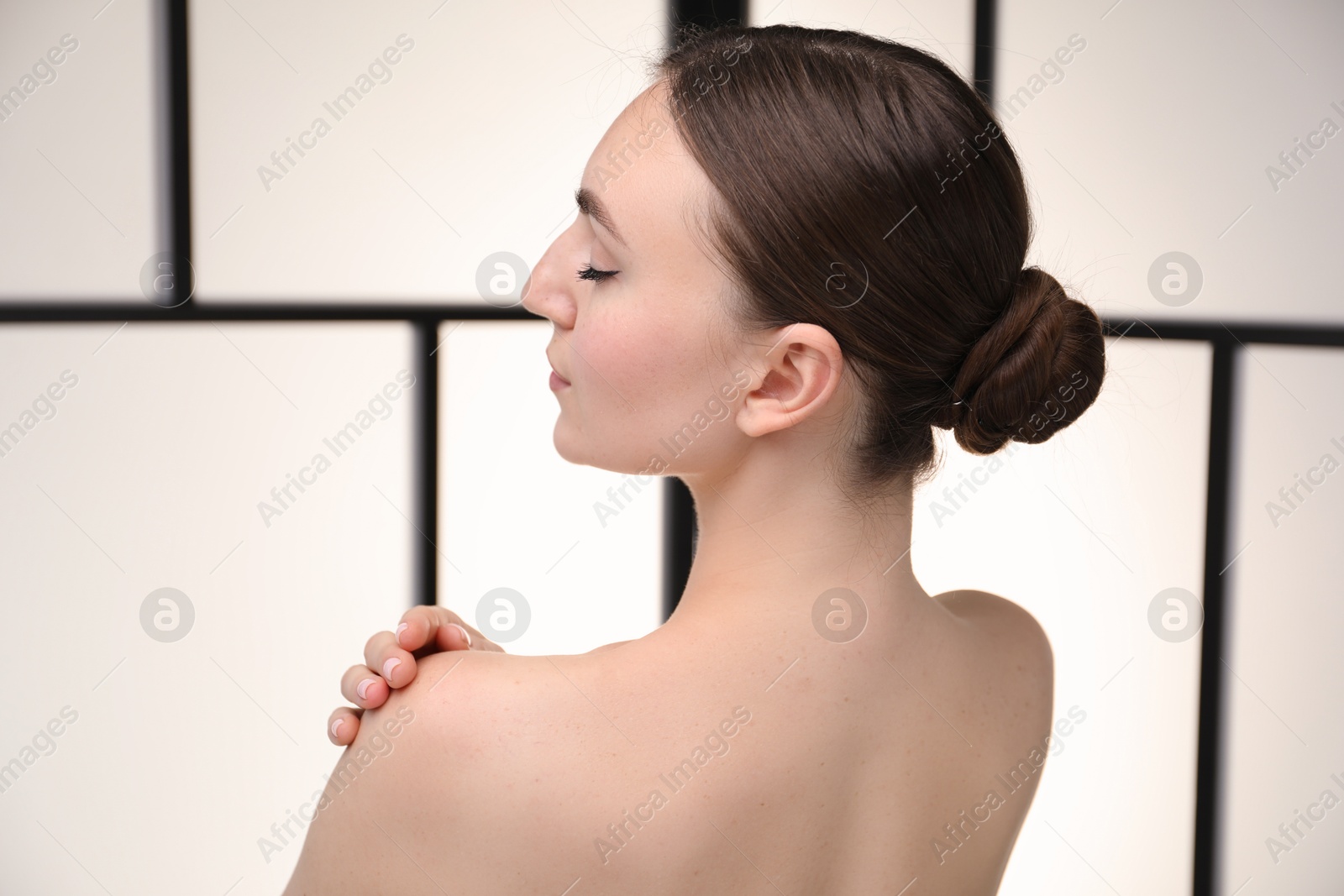 Beautiful woman on light background, back view Photo of Beautiful woman on light background, back view
