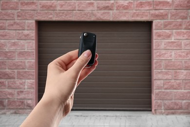 Image of Woman using remote to control garage door outdoors, closeup