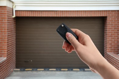 Image of Woman using remote to control garage door outdoors, closeup