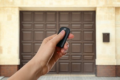 Image of Woman using remote to control electric gate outdoors, closeup