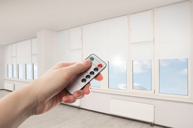 Image of Woman using remote to control blinds in room, closeup