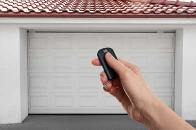 Image of Woman using remote to control garage door outdoors, closeup