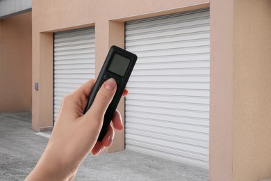Image of Woman using remote to control roller door outdoors, closeup