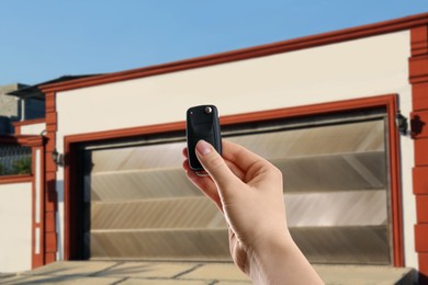 Image of Woman using remote to control garage door outdoors, closeup