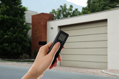 Image of Woman using remote to control garage door outdoors, closeup