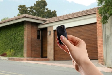 Image of Woman using remote to control electric gate outdoors, closeup