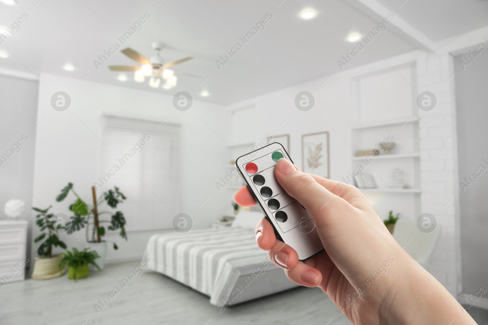 Woman using remote to control lighting in room, closeup Image of Woman using remote to control lighting in room, closeup