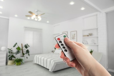 Image of Woman using remote to control lighting in room, closeup