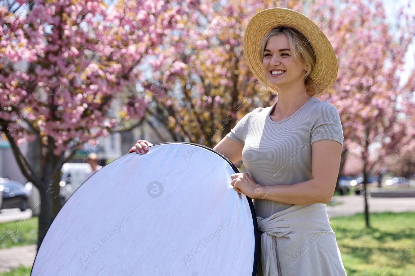 Woman with reflector outdoors on sunny day. Photography equipment Photo of Woman with reflector outdoors on sunny day. Photography equipment