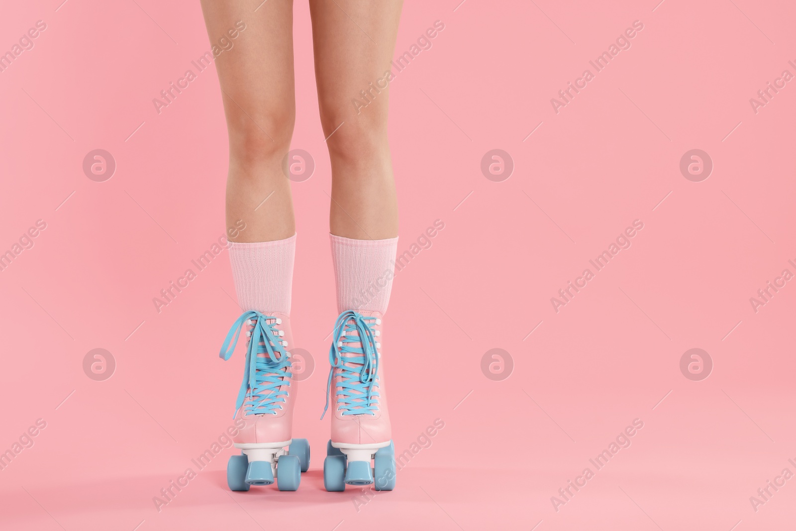 Woman in roller skates on pink background, closeup. Space for text Photo of Woman in roller skates on pink background, closeup. Space for text