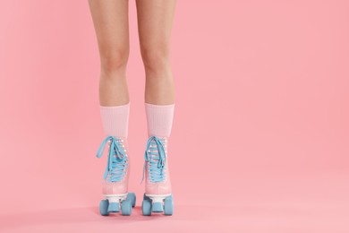 Photo of Woman in roller skates on pink background, closeup. Space for text