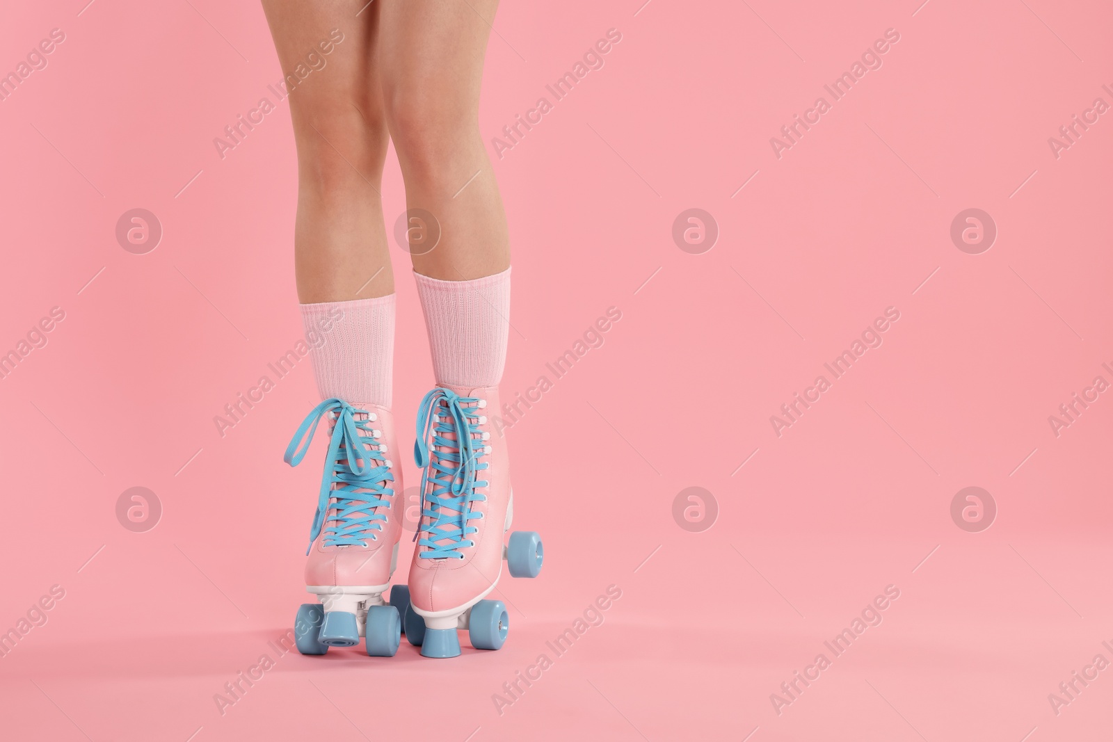 Woman in roller skates on pink background, closeup. Space for text Photo of Woman in roller skates on pink background, closeup. Space for text