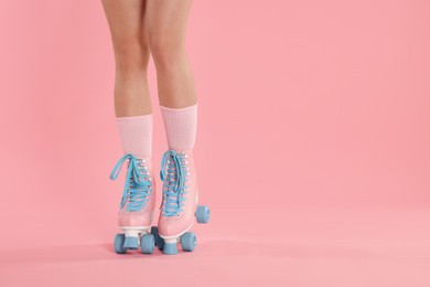 Photo of Woman in roller skates on pink background, closeup. Space for text
