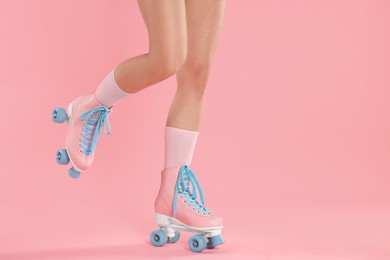 Photo of Woman in roller skates on pink background, closeup. Space for text