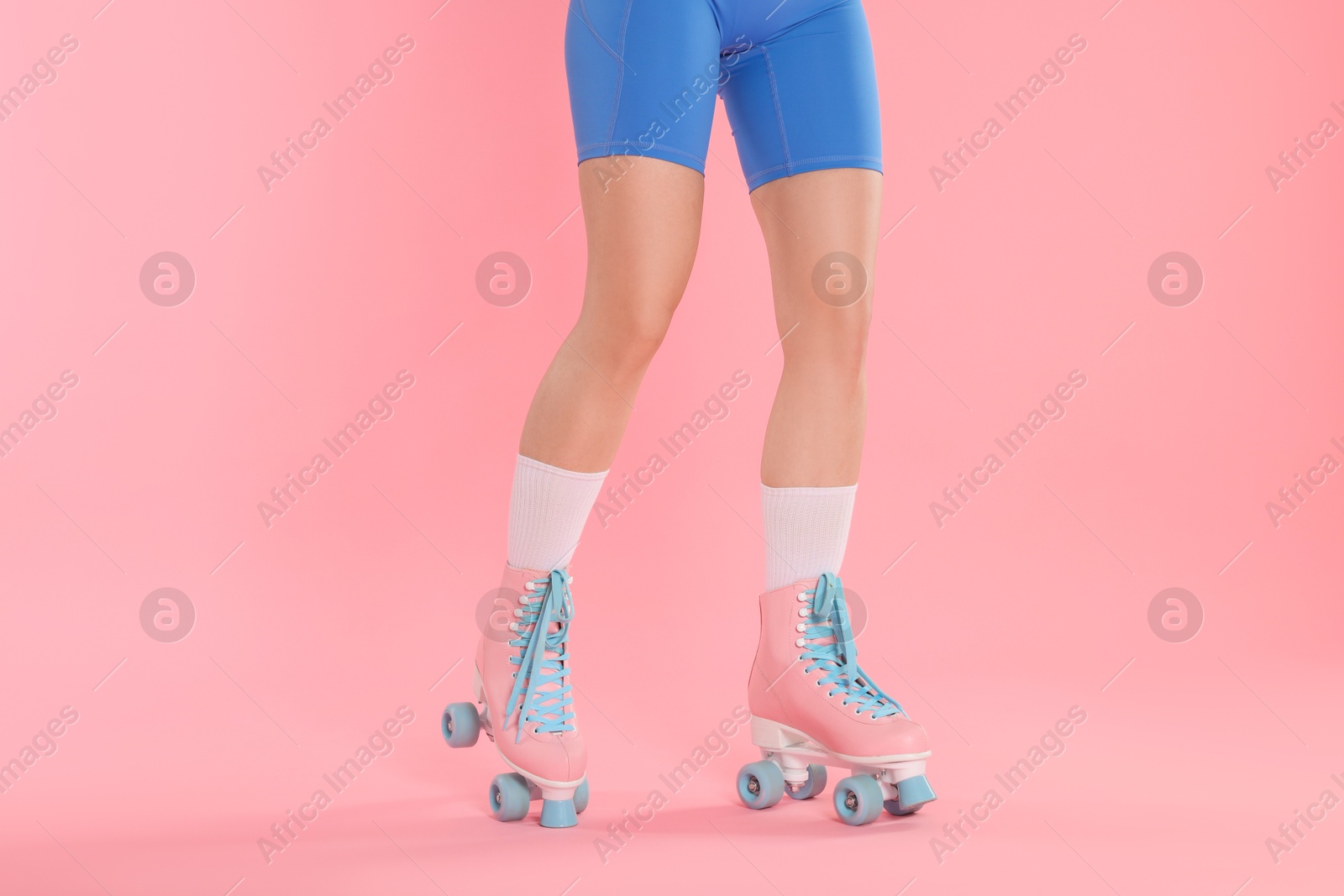 Woman in roller skates on pink background, closeup Photo of Woman in roller skates on pink background, closeup