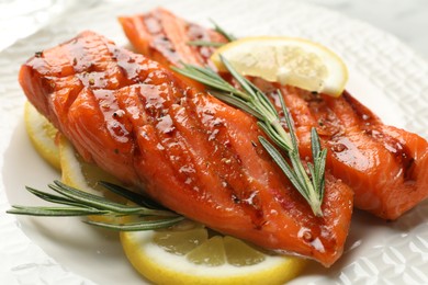 Photo of Seafood. Tasty grilled salmon served with rosemary and lemon on table, closeup