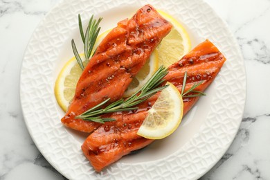 Photo of Seafood. Tasty grilled salmon served with rosemary and lemon on white marble table, top view