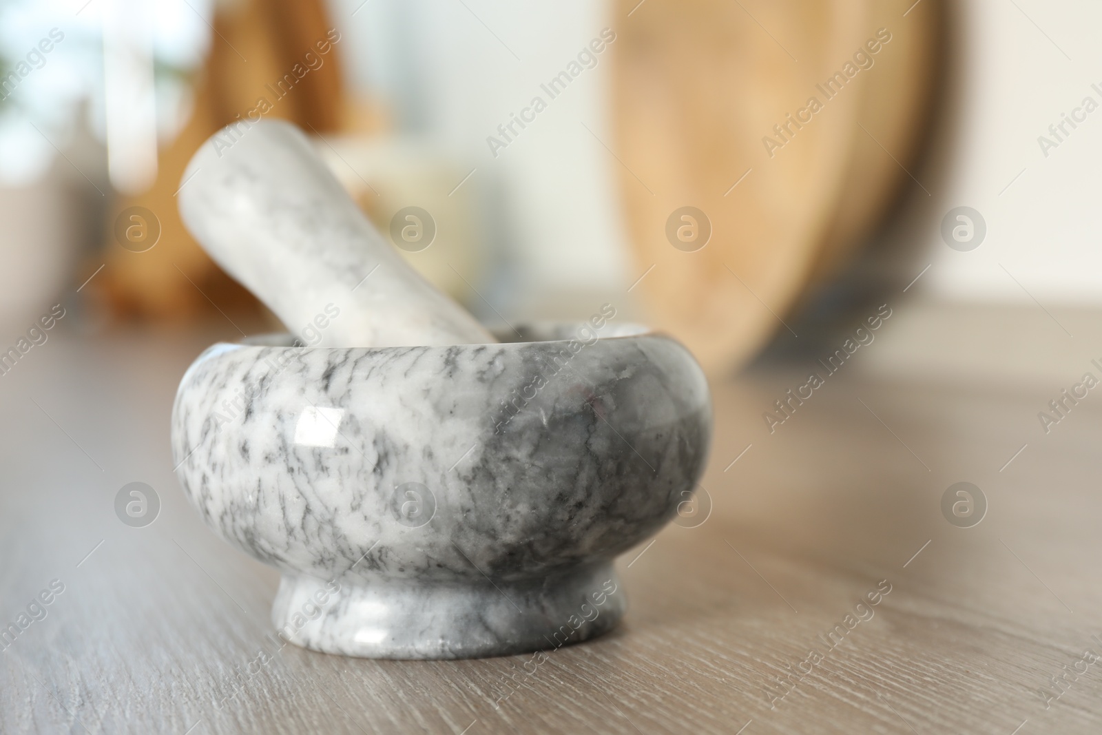Marble mortar and pestle on wooden table in kitchen, closeup. Space for text Photo of Marble mortar and pestle on wooden table in kitchen, closeup. Space for text