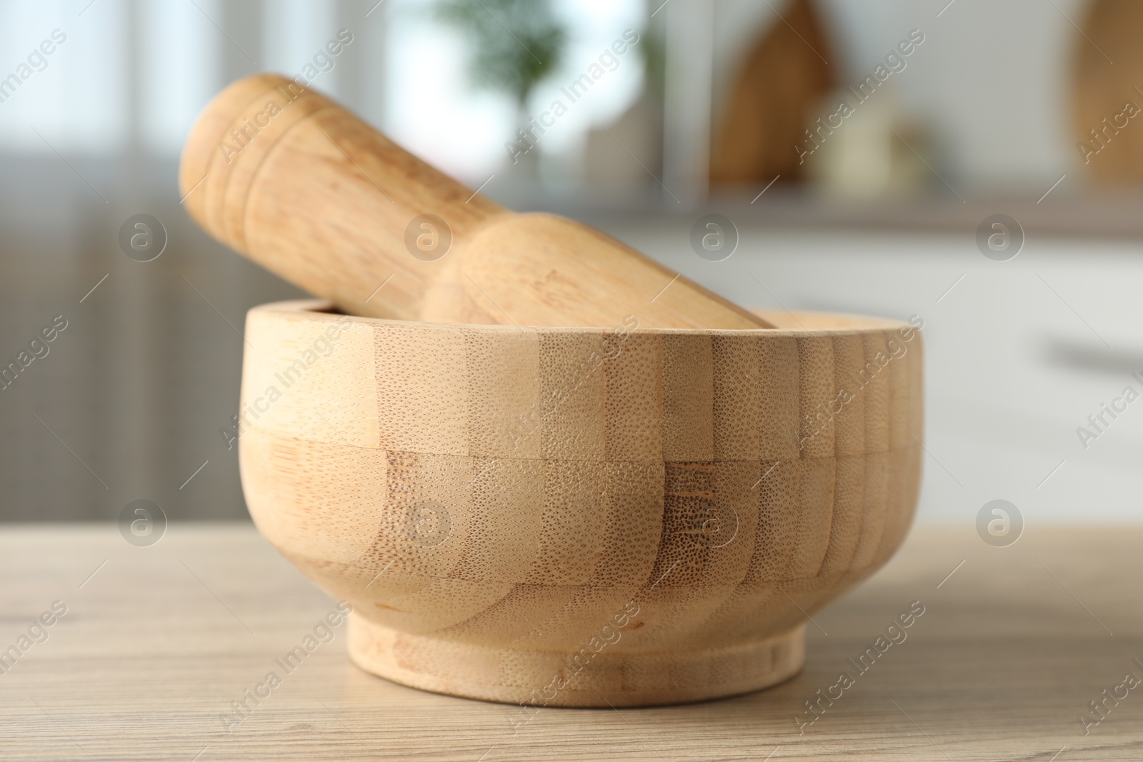 Mortar and pestle on wooden table in kitchen, closeup Photo of Mortar and pestle on wooden table in kitchen, closeup