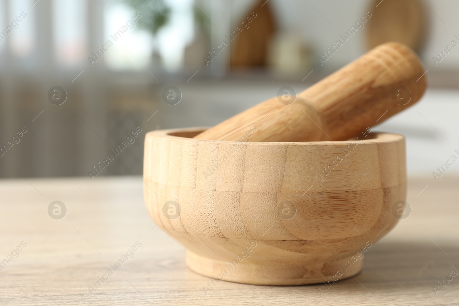 Mortar and pestle on wooden table in kitchen, closeup Photo of Mortar and pestle on wooden table in kitchen, closeup