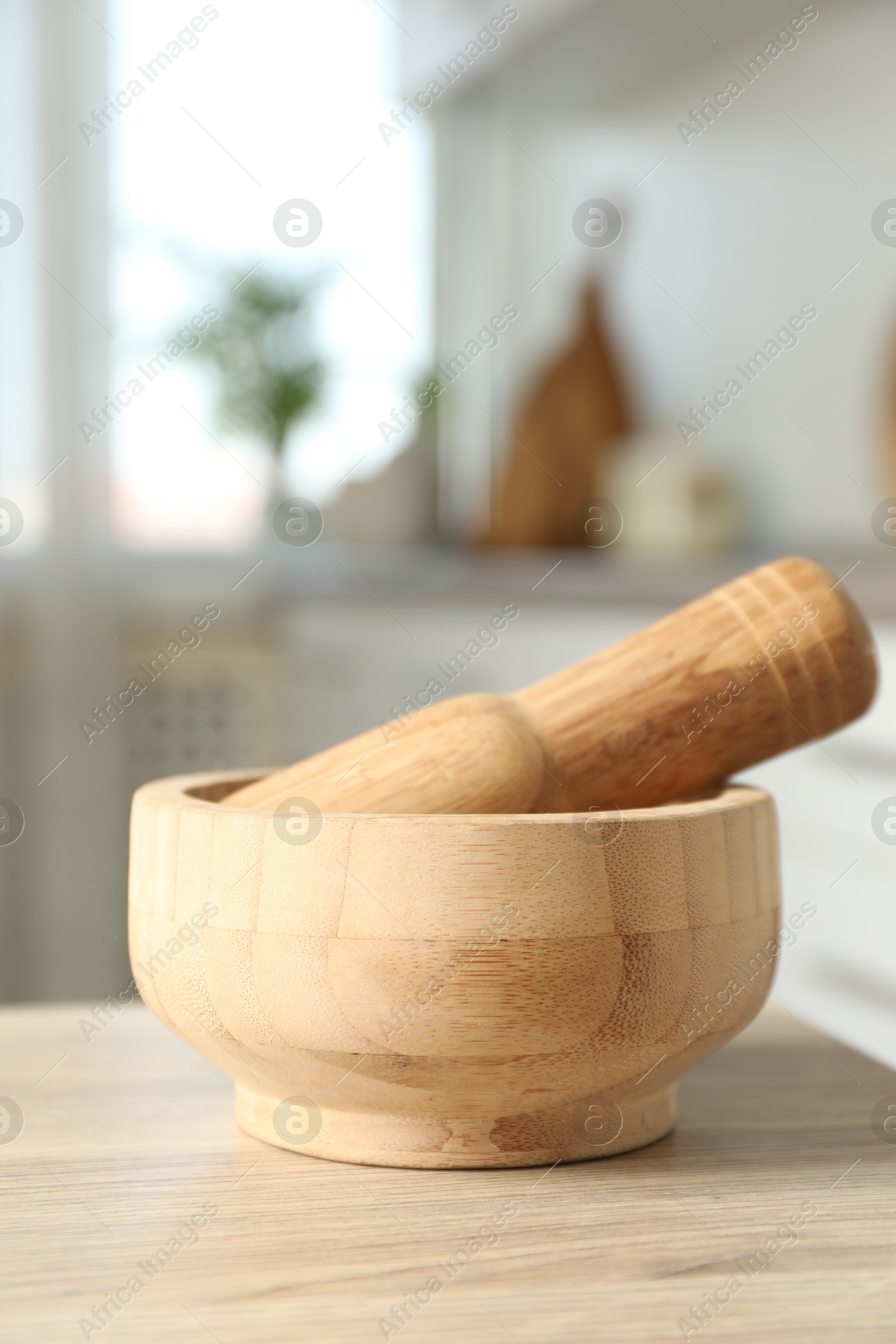 Mortar and pestle on wooden table in kitchen, closeup Photo of Mortar and pestle on wooden table in kitchen, closeup