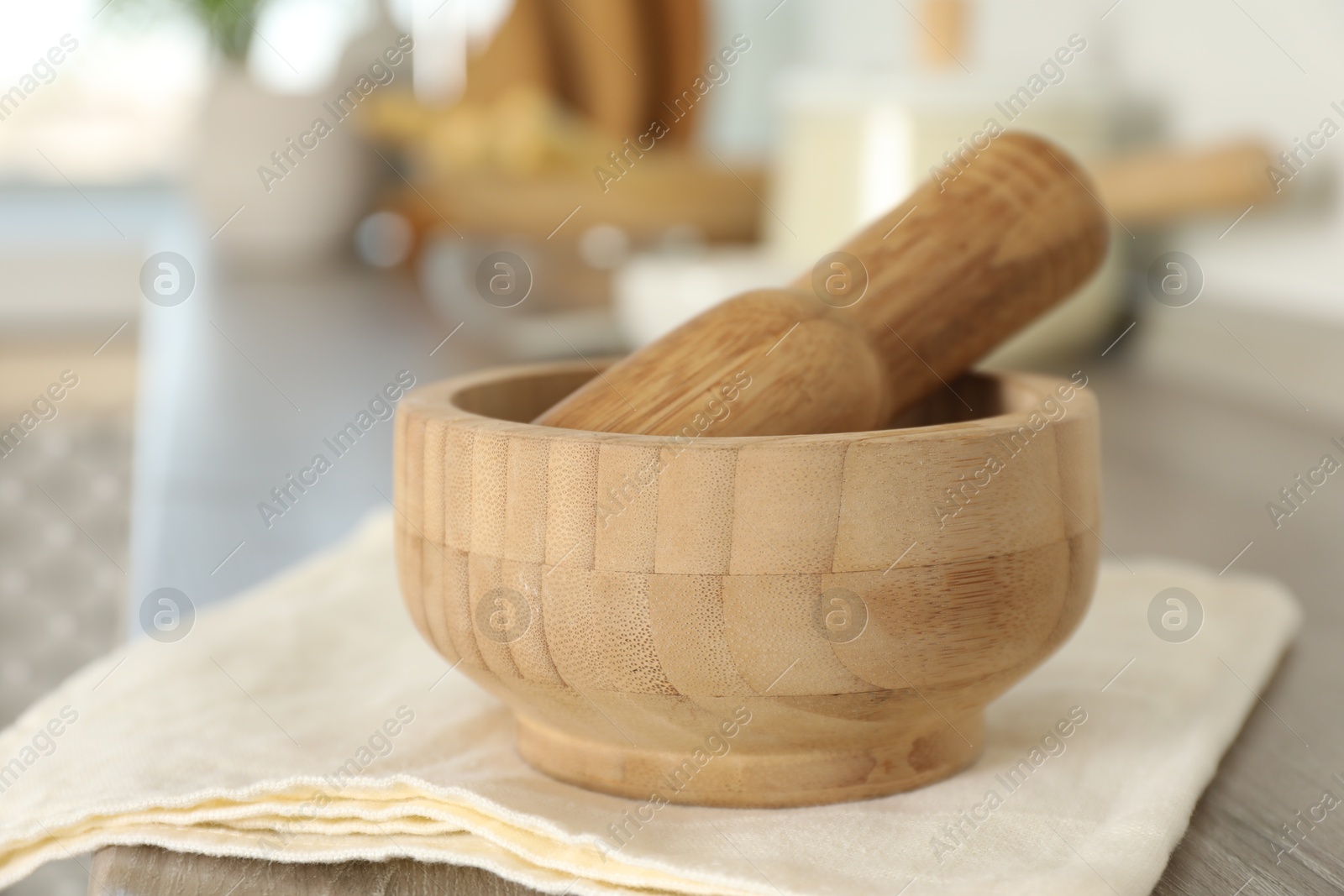 Mortar and pestle on wooden table in kitchen, closeup Photo of Mortar and pestle on wooden table in kitchen, closeup