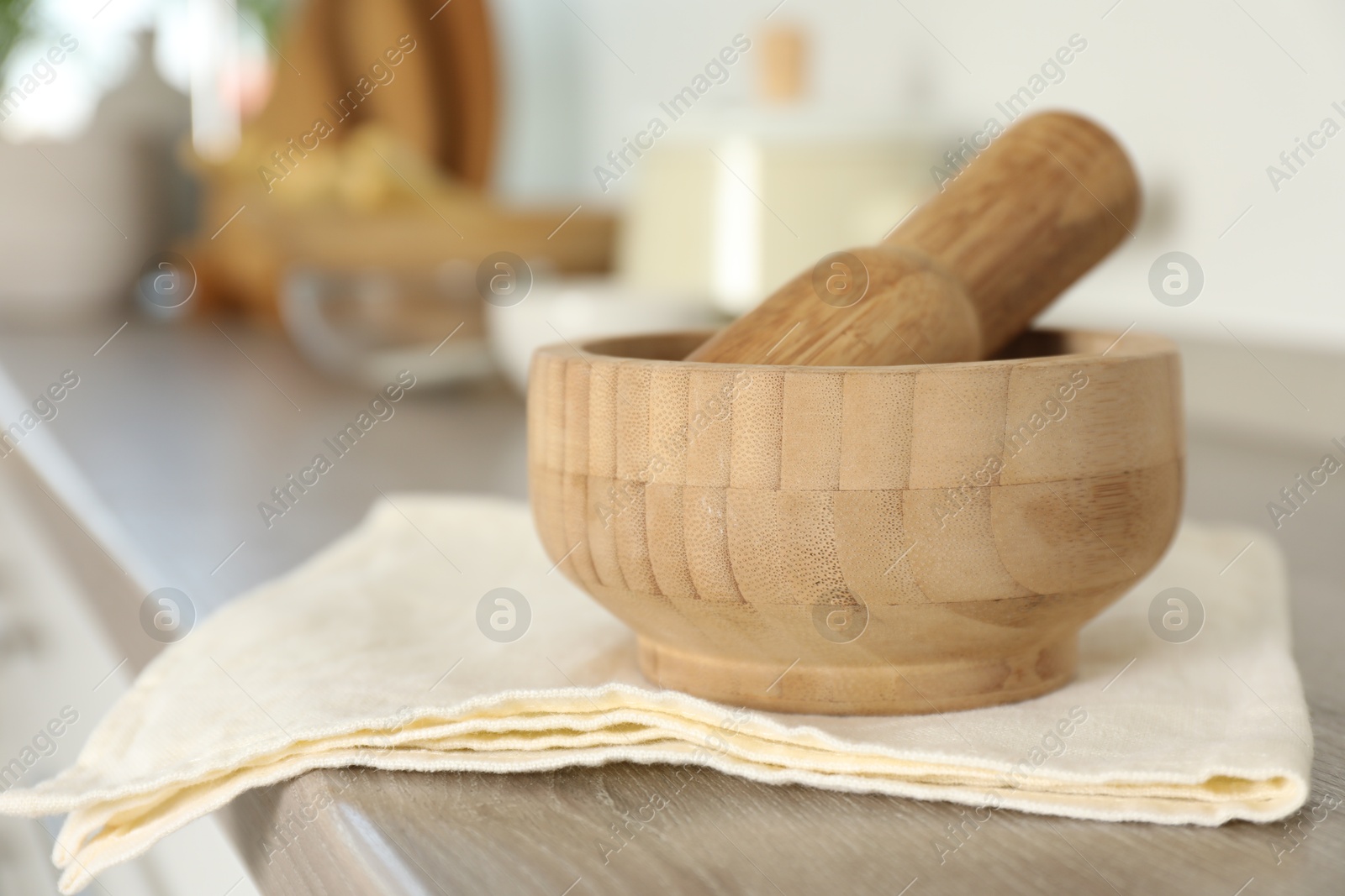 Mortar and pestle on wooden table in kitchen, closeup Photo of Mortar and pestle on wooden table in kitchen, closeup