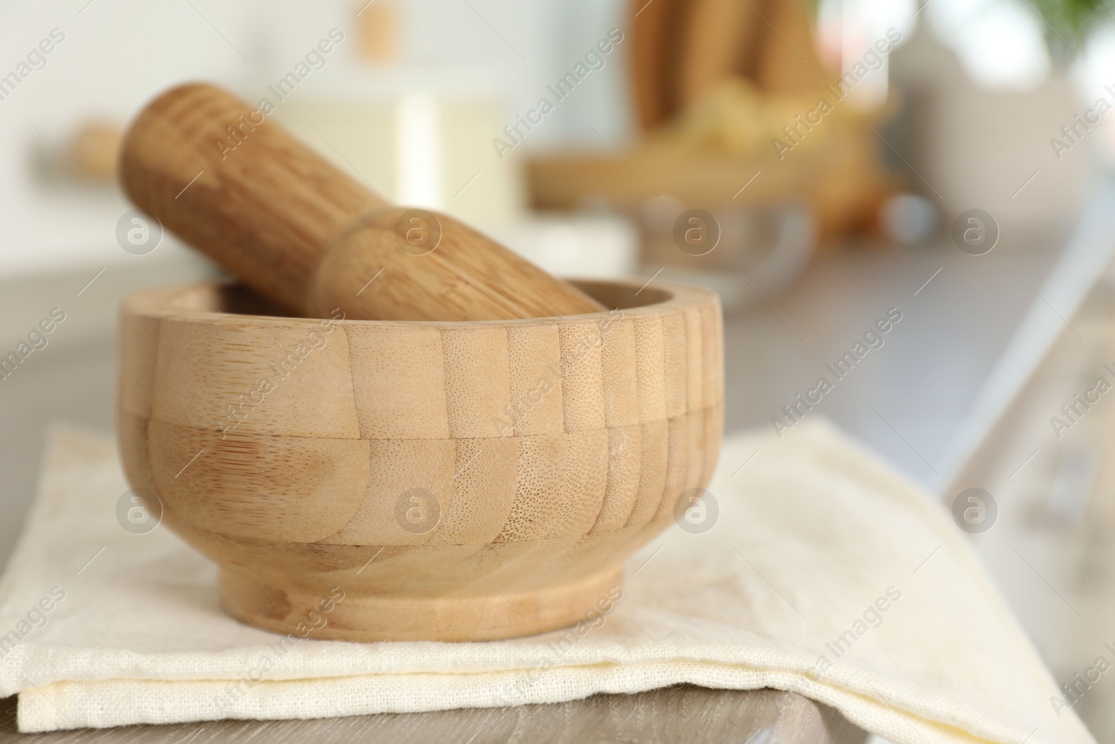Mortar and pestle on wooden table in kitchen, closeup Photo of Mortar and pestle on wooden table in kitchen, closeup