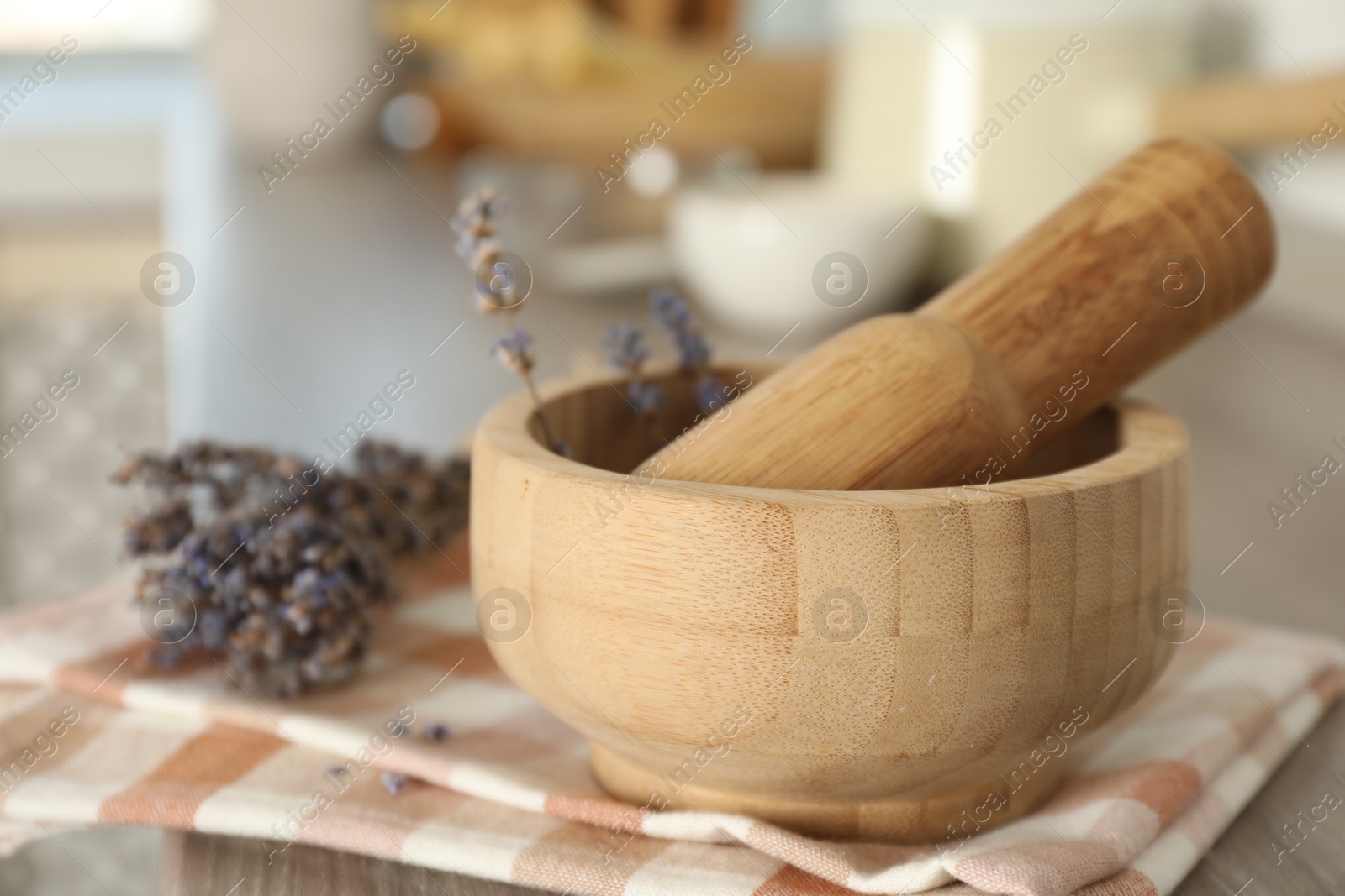 Mortar with lavender and pestle on wooden table in kitchen, closeup Photo of Mortar with lavender and pestle on wooden table in kitchen, closeup