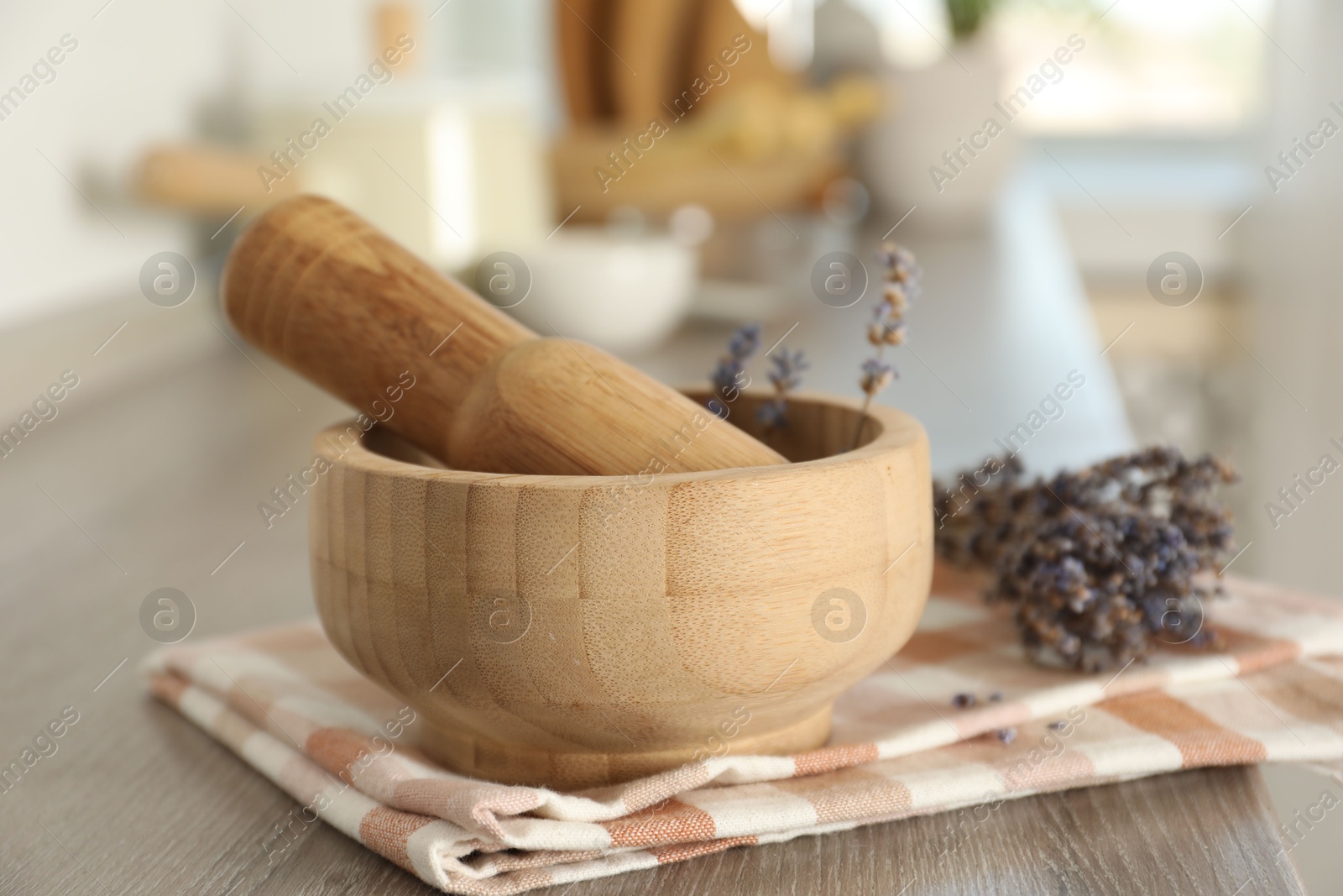 Mortar with lavender and pestle on wooden table in kitchen, closeup Photo of Mortar with lavender and pestle on wooden table in kitchen, closeup