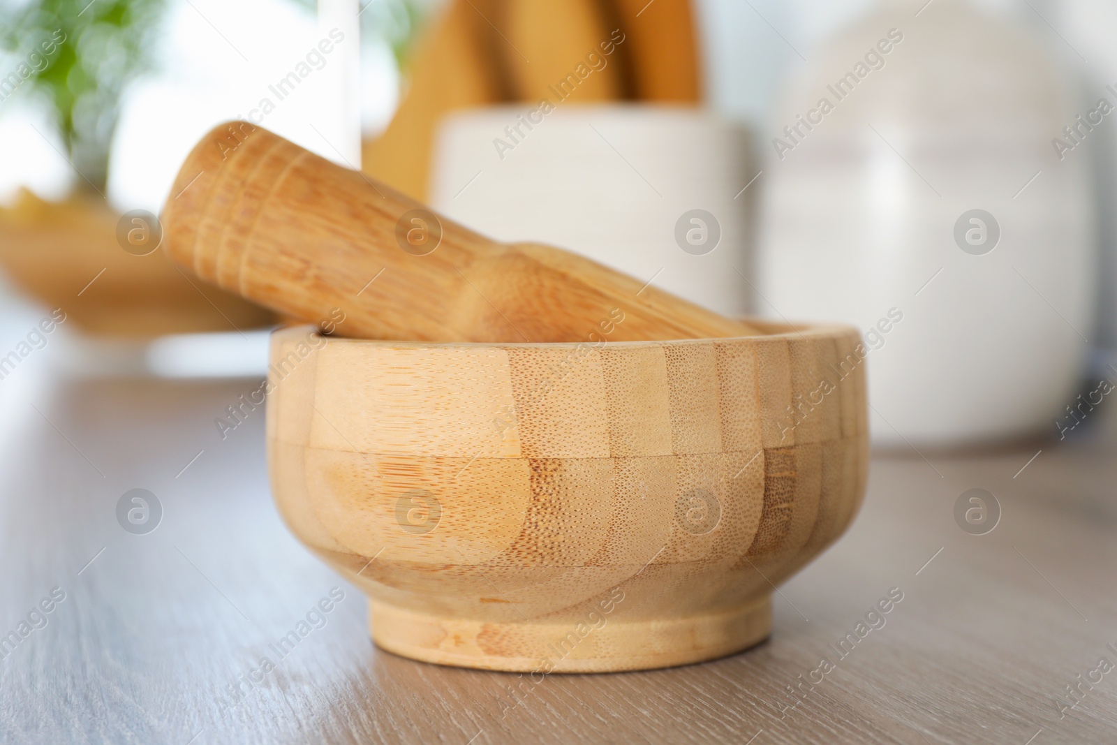 Mortar and pestle on wooden table in kitchen, closeup Photo of Mortar and pestle on wooden table in kitchen, closeup