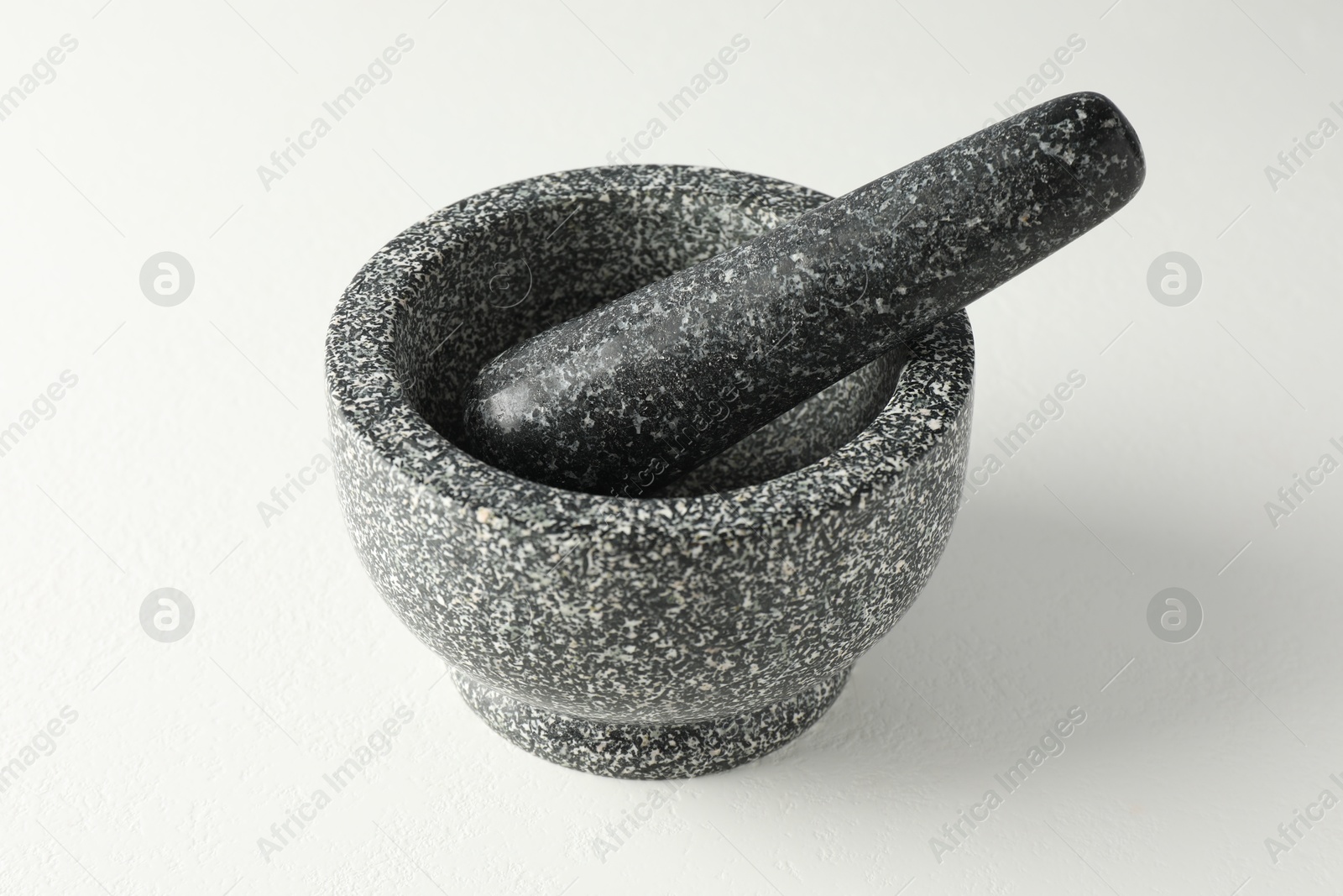 Stone mortar and pestle on white table, closeup Photo of Stone mortar and pestle on white table, closeup