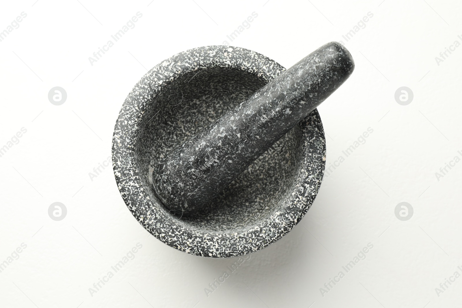 Stone mortar and pestle on white table, top view Photo of Stone mortar and pestle on white table, top view