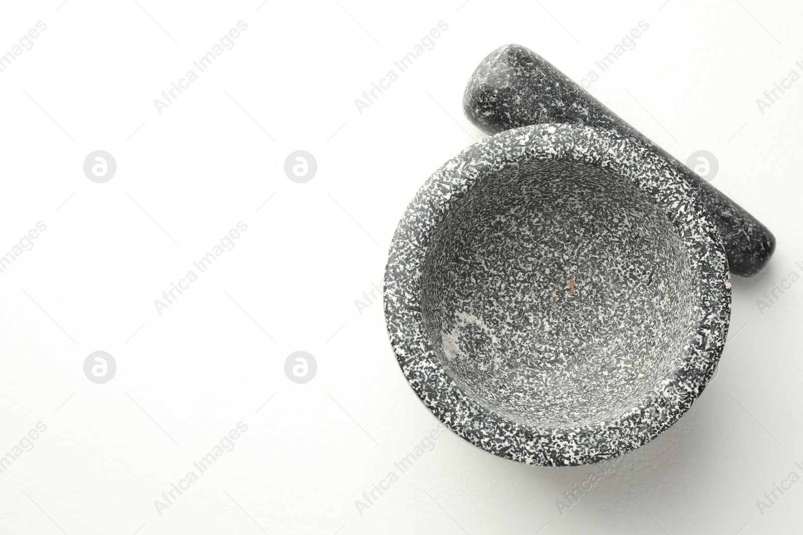 Stone mortar and pestle on white table, top view. Space for text Photo of Stone mortar and pestle on white table, top view. Space for text