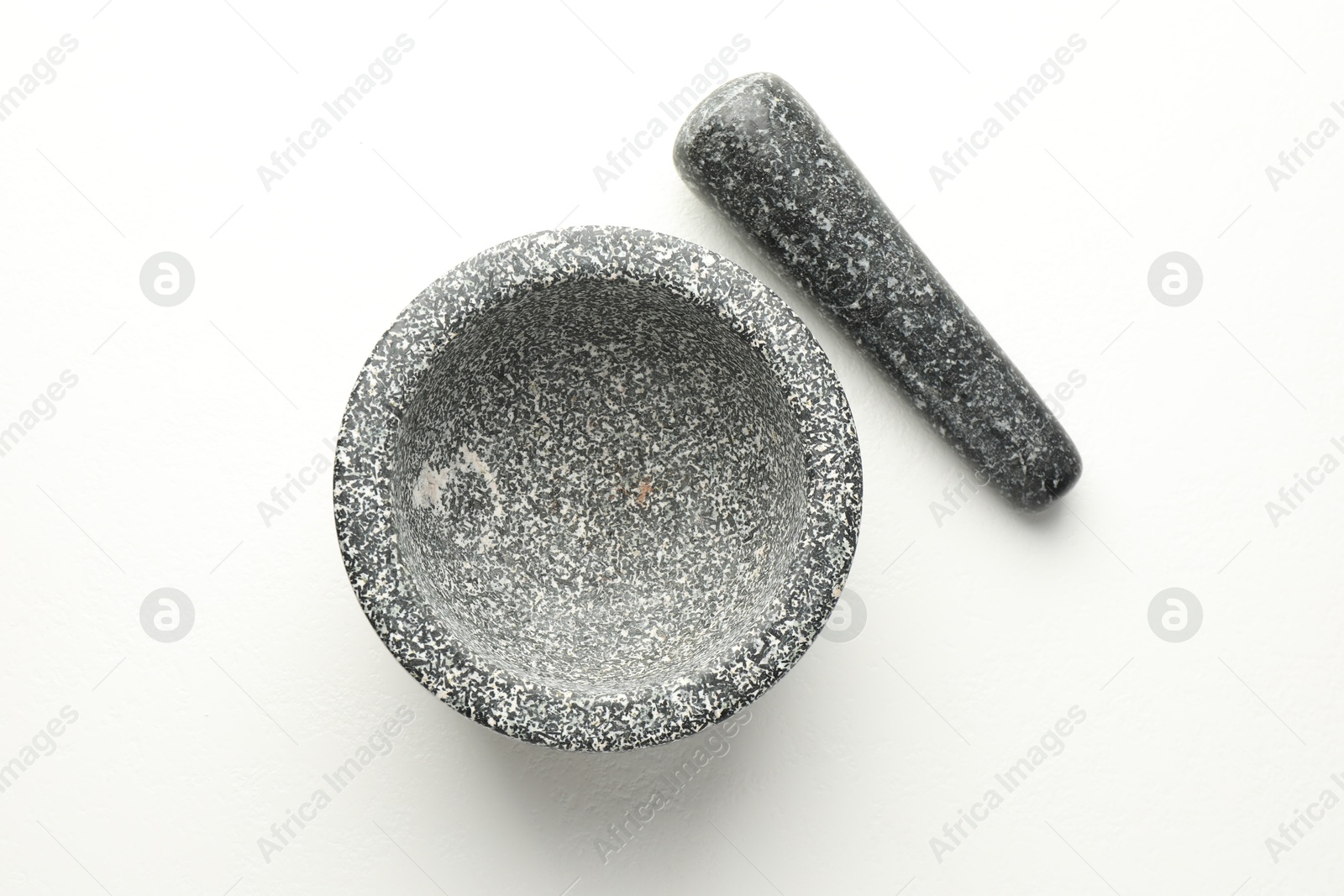 Stone mortar and pestle on white table, top view Photo of Stone mortar and pestle on white table, top view