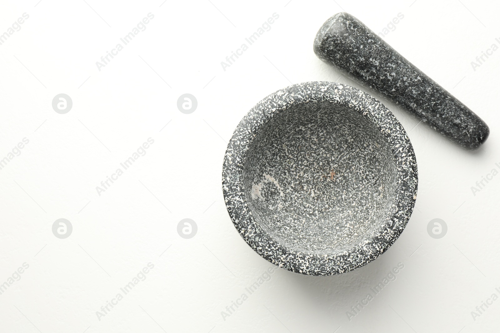 Stone mortar and pestle on white table, top view. Space for text Photo of Stone mortar and pestle on white table, top view. Space for text