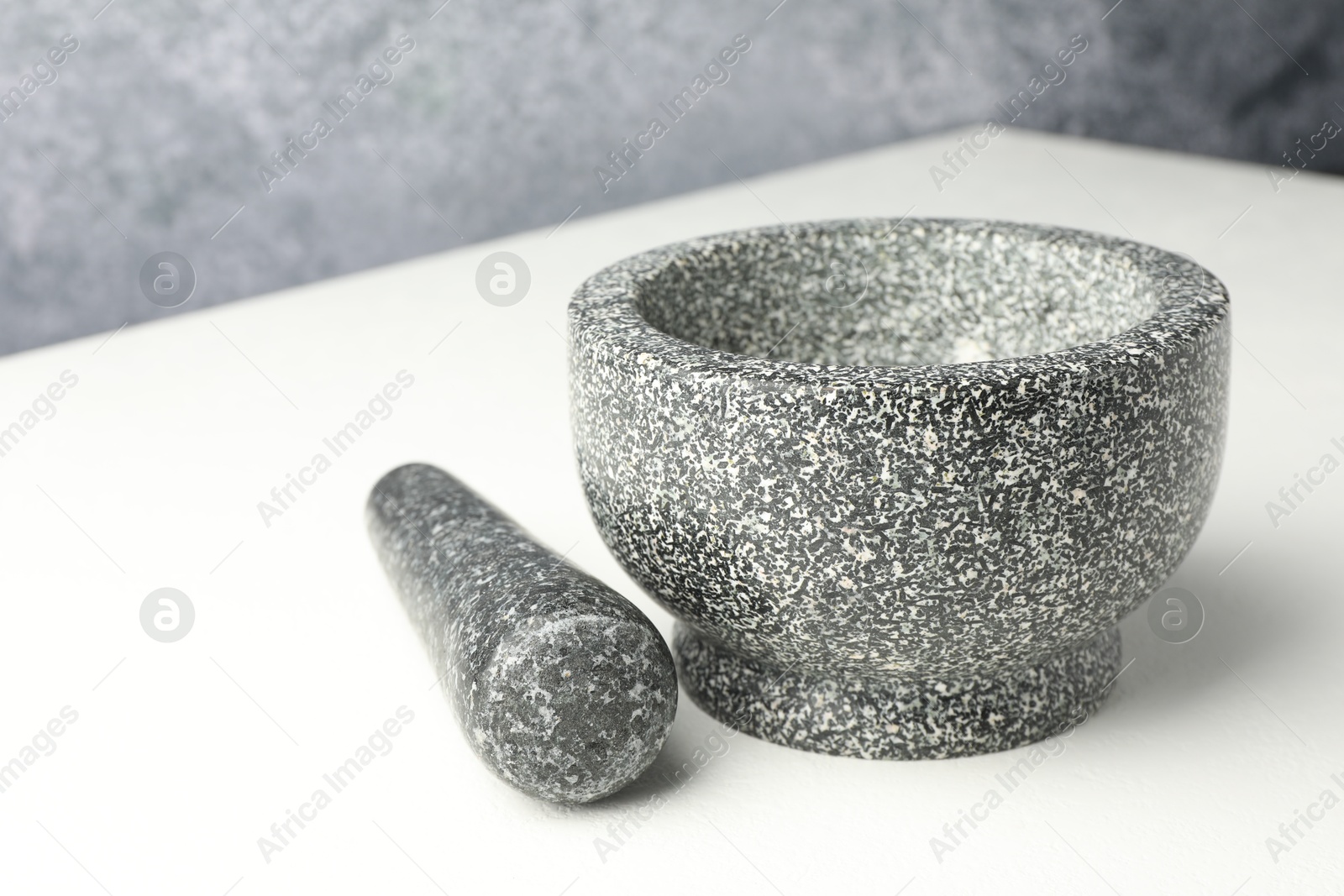 Stone mortar and pestle on white table, closeup Photo of Stone mortar and pestle on white table, closeup