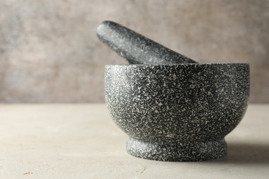 Photo of Stone mortar and pestle on light table, closeup