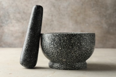 Photo of Stone mortar and pestle on light table, closeup