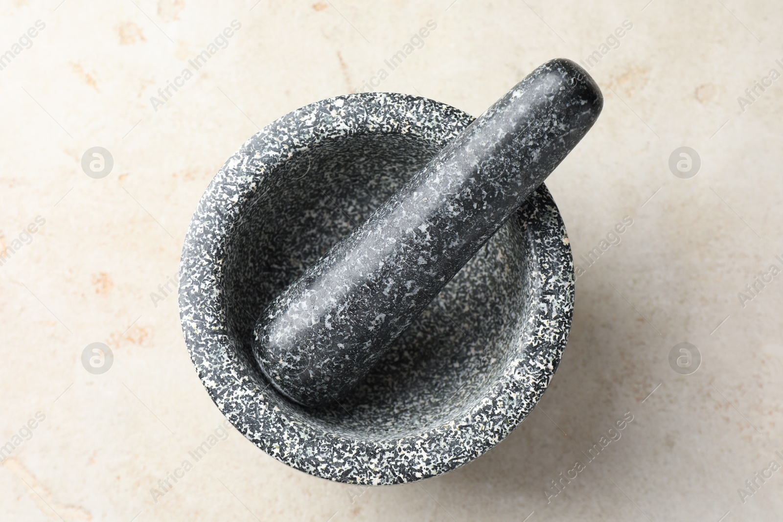 Stone mortar and pestle on light table, top view Photo of Stone mortar and pestle on light table, top view