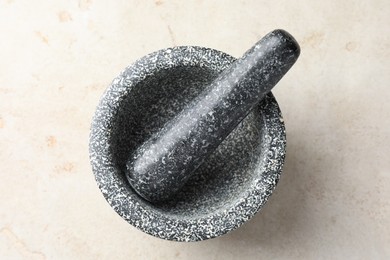 Photo of Stone mortar and pestle on light table, top view
