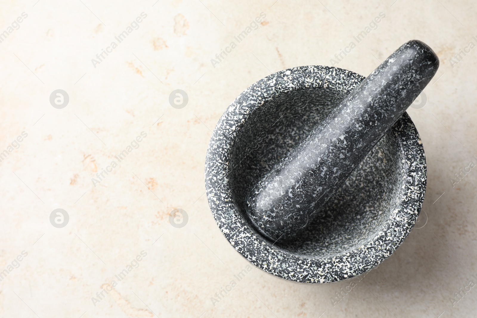 Stone mortar and pestle on light table, top view. Space for text Photo of Stone mortar and pestle on light table, top view. Space for text