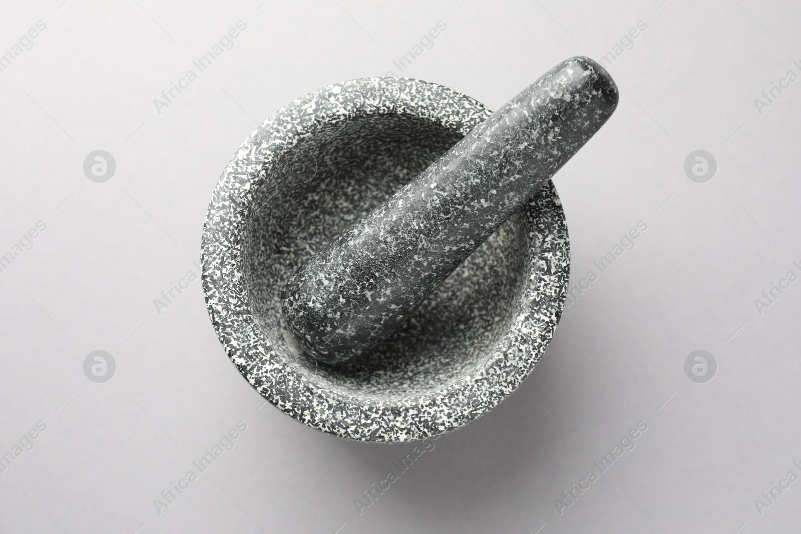 Stone mortar and pestle on light grey background, top view Photo of Stone mortar and pestle on light grey background, top view