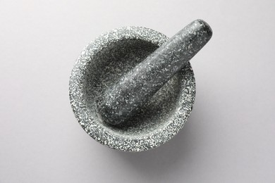 Photo of Stone mortar and pestle on light grey background, top view