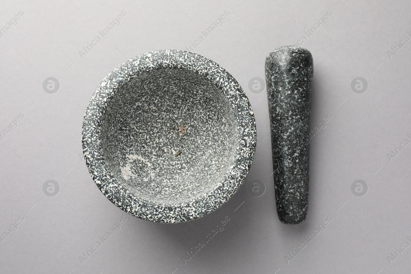 Stone mortar and pestle on light grey background, top view Photo of Stone mortar and pestle on light grey background, top view