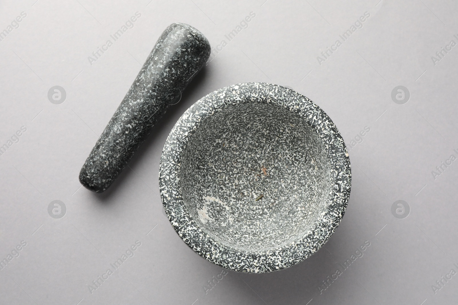 Stone mortar and pestle on light grey background, top view Photo of Stone mortar and pestle on light grey background, top view
