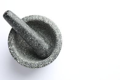 Photo of Stone mortar and pestle on white background, top view. Space for text