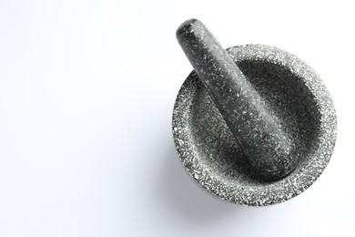 Photo of Stone mortar and pestle on white background, top view. Space for text