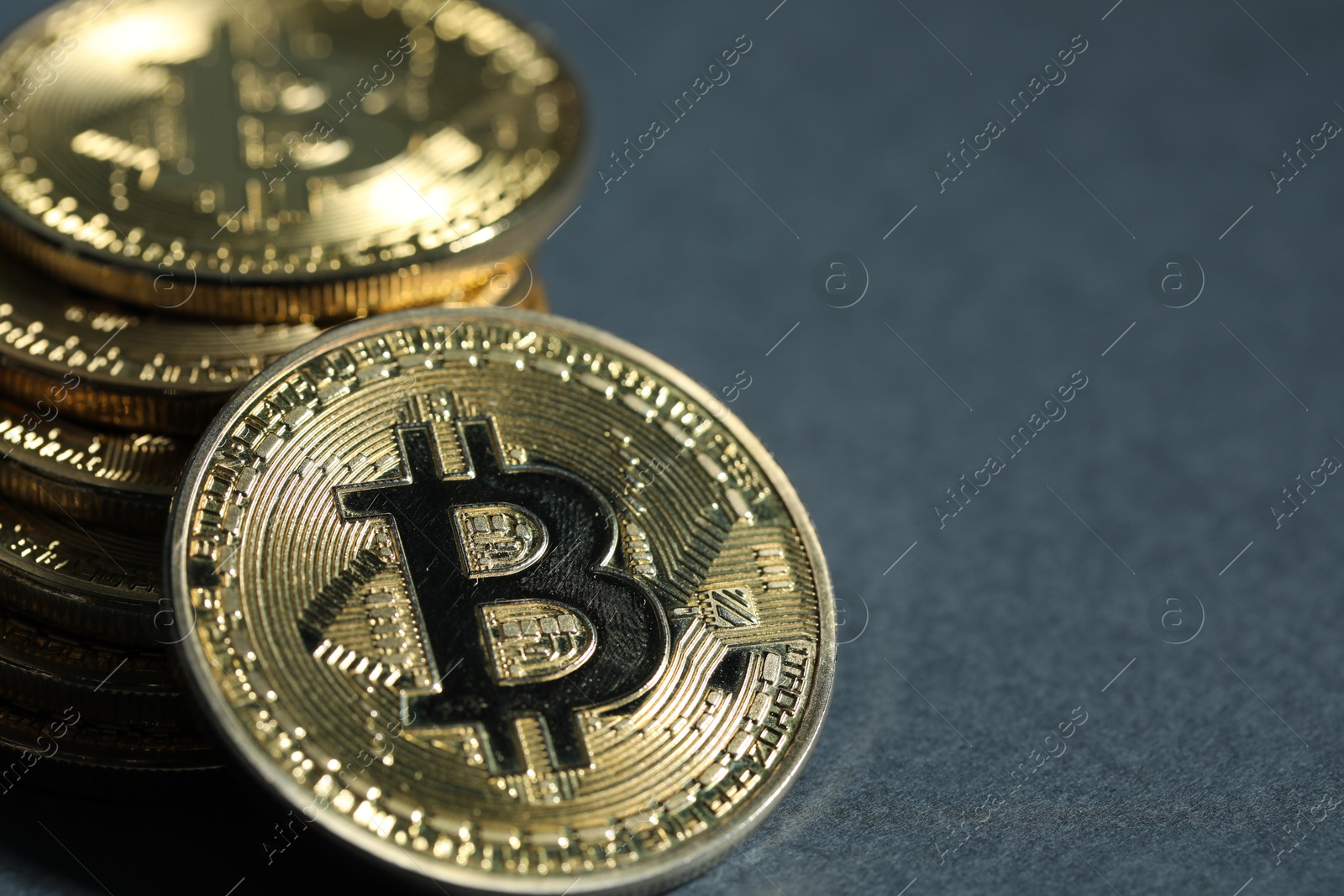 Cryptocurrency. Golden bitcoins on grey background, closeup. Space for text Photo of Cryptocurrency. Golden bitcoins on grey background, closeup. Space for text