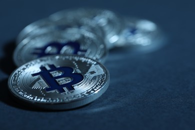 Photo of Cryptocurrency. Silver bitcoins on dark blue background, closeup
